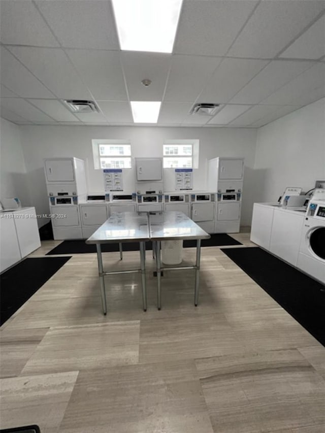 dining space featuring a drop ceiling, stacked washer / dryer, and separate washer and dryer