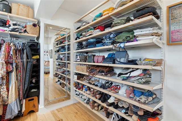 walk in closet with light hardwood / wood-style flooring