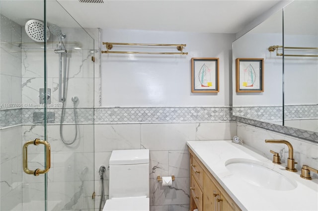 bathroom featuring tile walls, vanity, toilet, and an enclosed shower