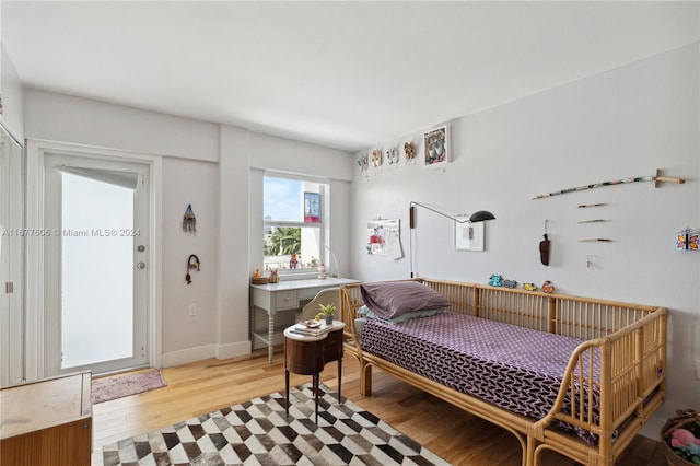 bedroom featuring breakfast area and light hardwood / wood-style floors