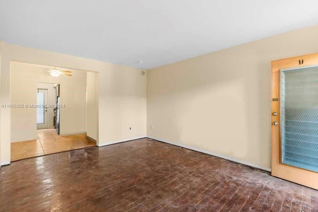 spare room with wood-type flooring and baseboards