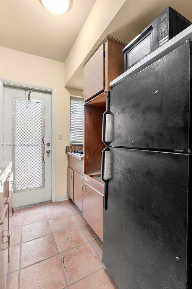 kitchen featuring light tile patterned floors and freestanding refrigerator