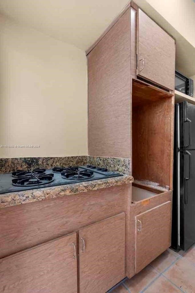 kitchen with light tile patterned floors and black appliances