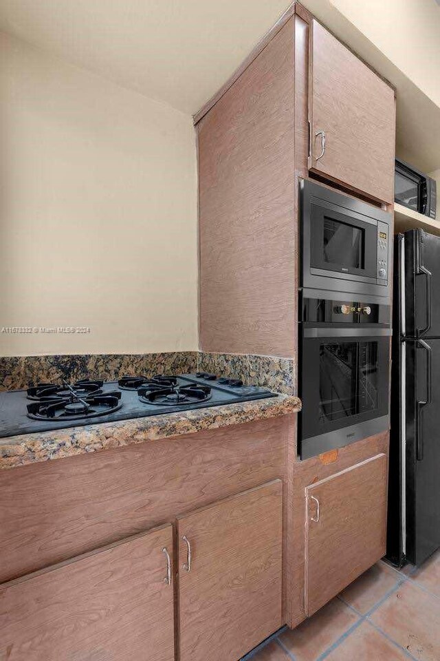 kitchen with light tile patterned floors and black appliances