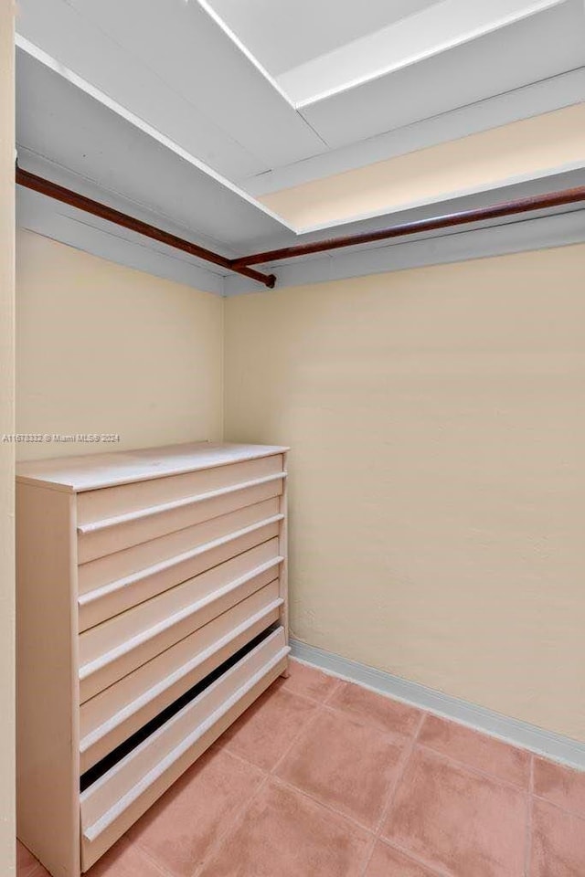 walk in closet with light tile patterned floors