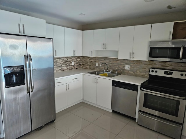 kitchen with sink, white cabinets, decorative backsplash, and stainless steel appliances