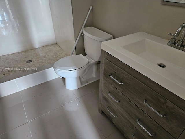 bathroom featuring vanity, toilet, a shower, and tile patterned flooring