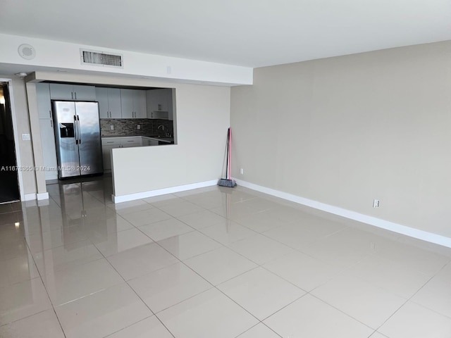 spare room featuring sink and light tile patterned floors