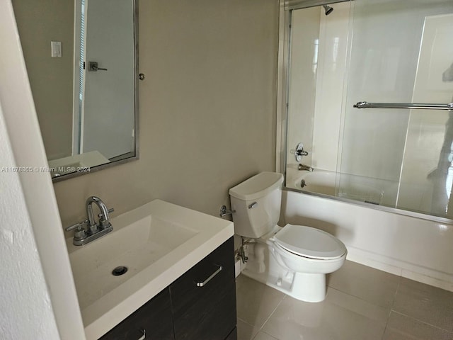 full bathroom with vanity, toilet, shower / bath combination with glass door, and tile patterned flooring