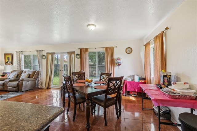 dining room with a textured ceiling and dark tile patterned flooring