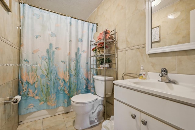 full bathroom featuring toilet, a textured ceiling, shower / bath combo with shower curtain, tile walls, and vanity