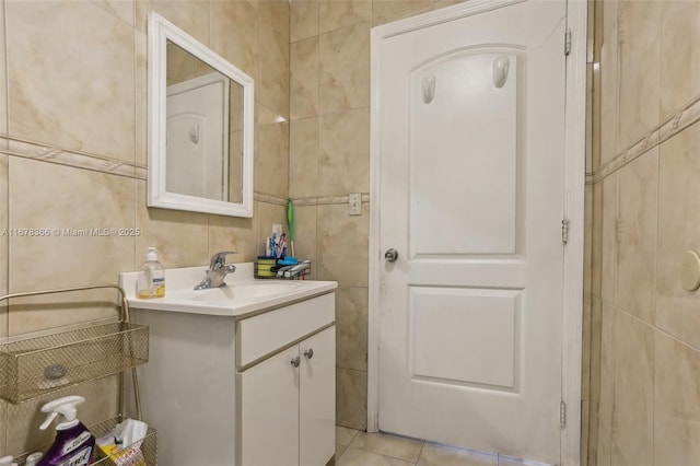 bathroom with tile walls, tile patterned flooring, and vanity