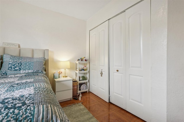 bedroom with tile patterned flooring and a closet