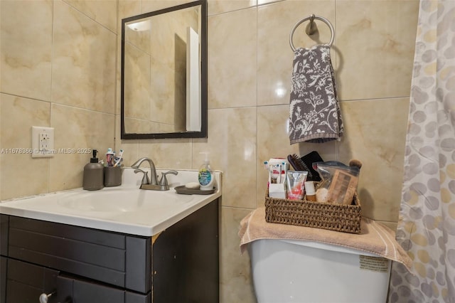 bathroom featuring vanity and tile walls