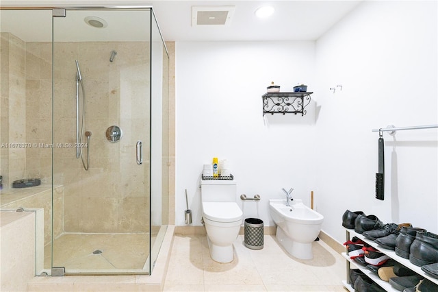 bathroom with tile patterned floors, toilet, an enclosed shower, and a bidet