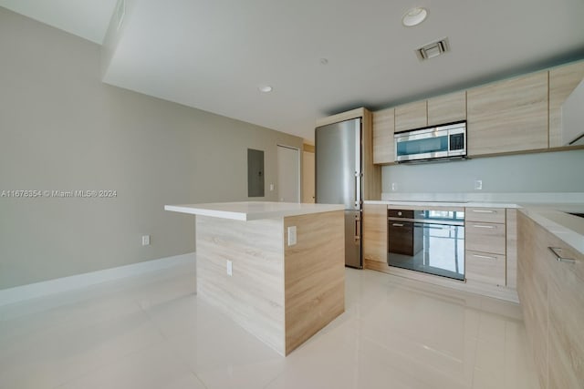 kitchen featuring a kitchen island, light brown cabinets, electric panel, oven, and light tile patterned flooring