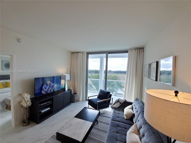 living room featuring marble finish floor and a wall of windows