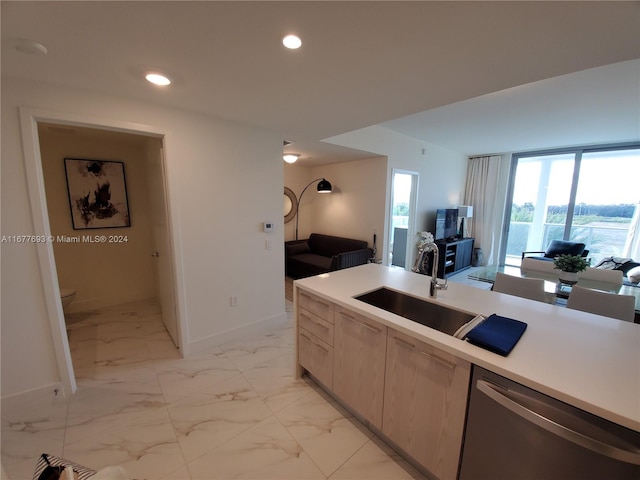 kitchen with sink, light brown cabinets, and dishwasher