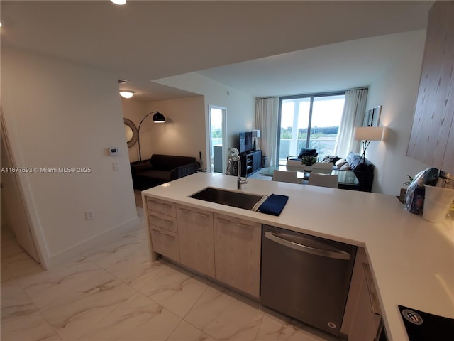 kitchen featuring marble finish floor, a sink, stainless steel dishwasher, and light brown cabinetry