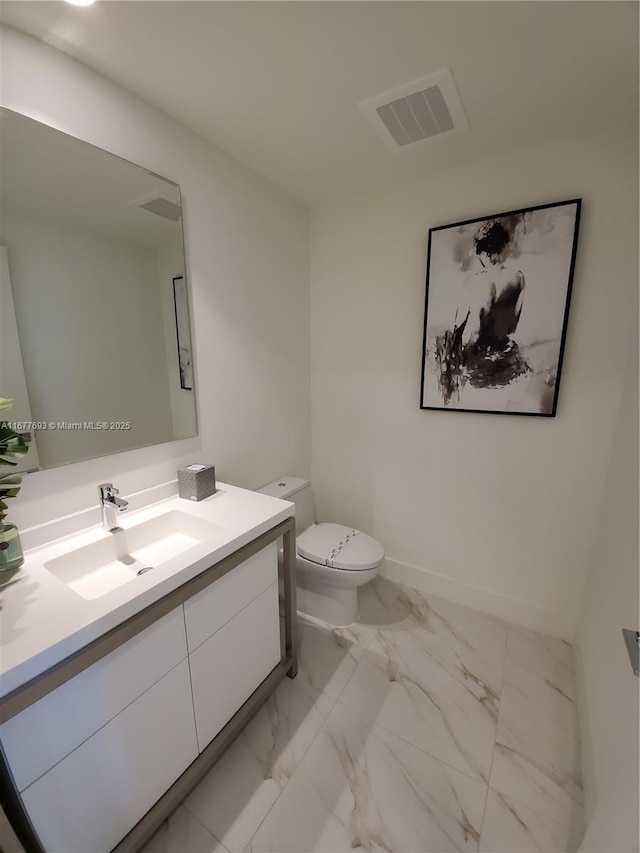 bathroom with baseboards, visible vents, toilet, marble finish floor, and vanity