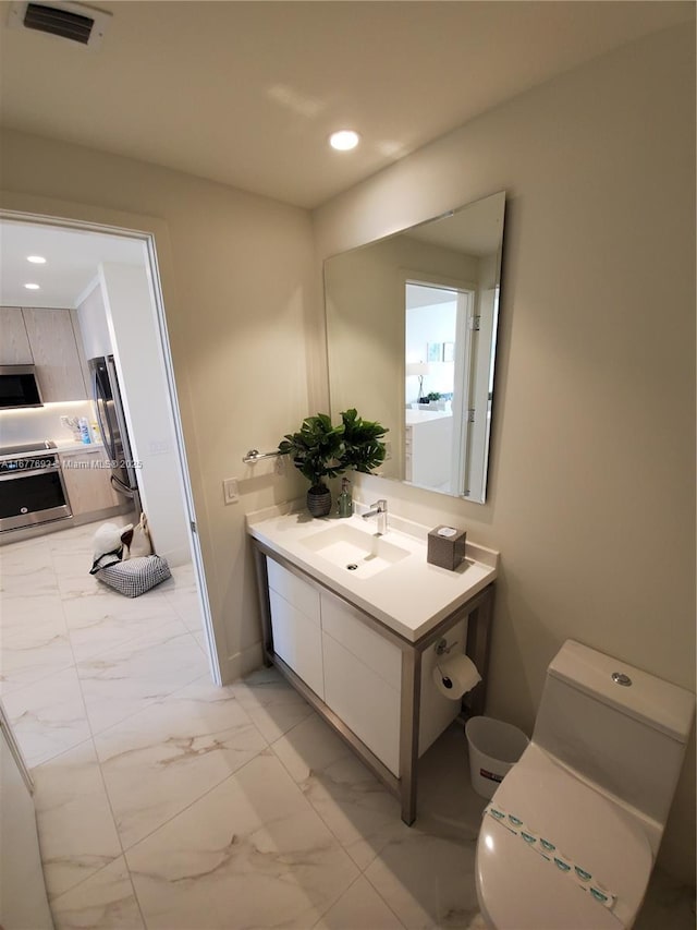 bathroom featuring marble finish floor, recessed lighting, visible vents, toilet, and vanity