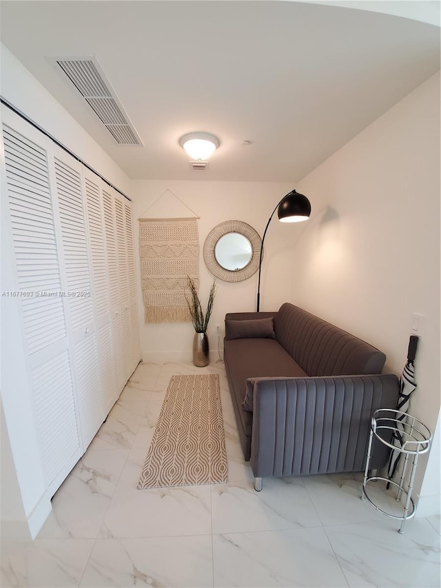 living area featuring marble finish floor and visible vents