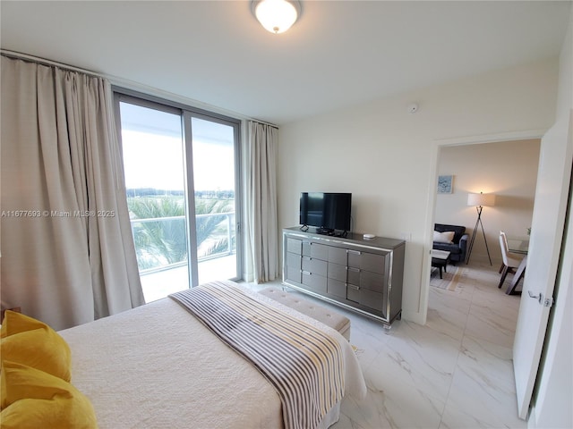 bedroom featuring marble finish floor, access to outside, and a wall of windows