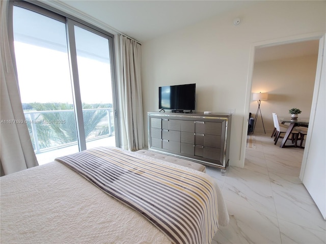 bedroom featuring marble finish floor, access to outside, and a wall of windows