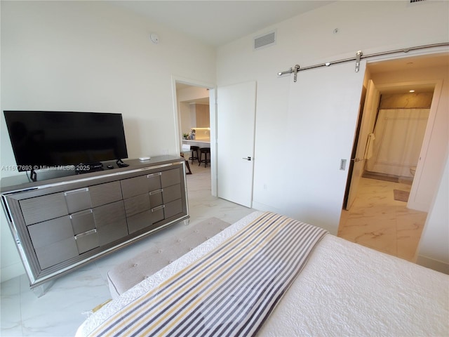 bedroom with marble finish floor, visible vents, and a barn door