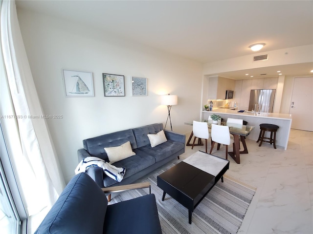 living area featuring marble finish floor and visible vents