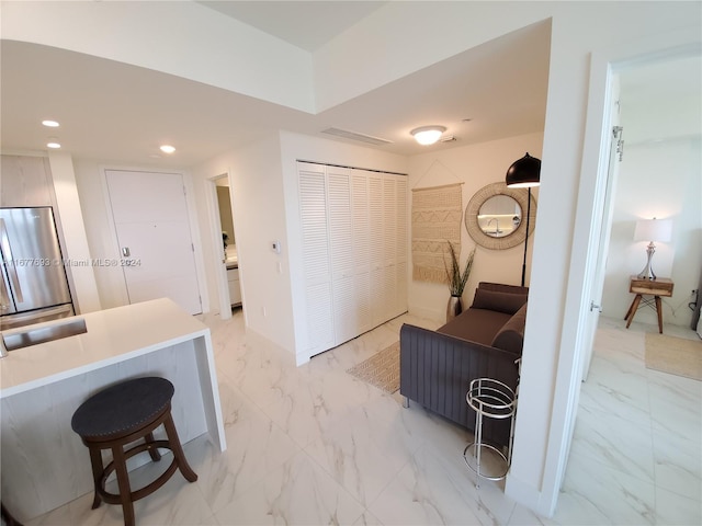 interior space featuring a breakfast bar and stainless steel fridge