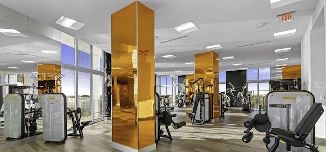 exercise room with a wall of windows and wood finished floors