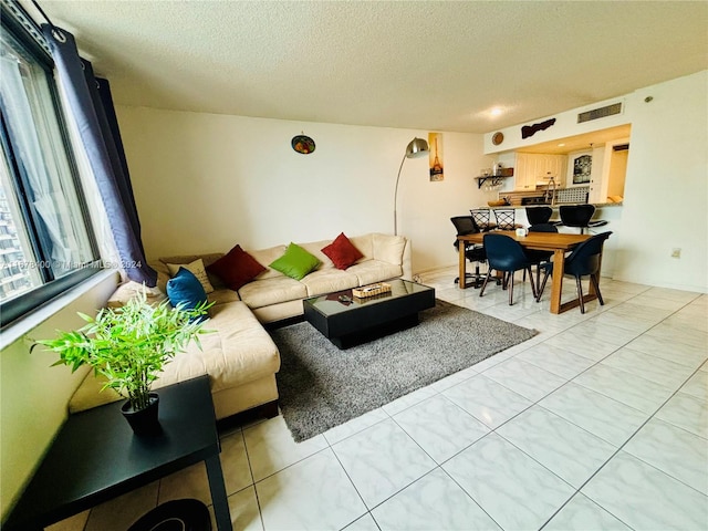 living room featuring a textured ceiling and tile patterned floors