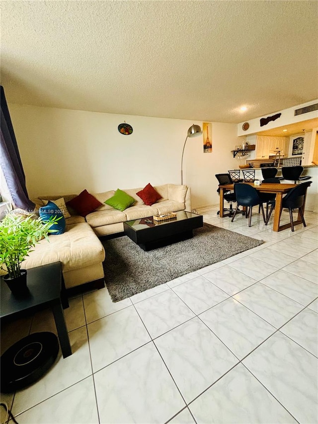 living room with a textured ceiling and tile patterned flooring