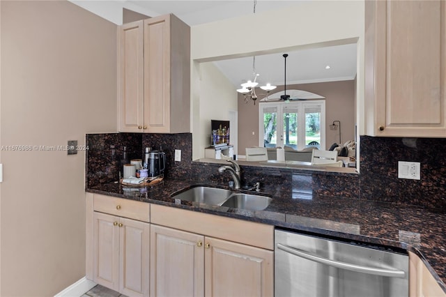 kitchen featuring decorative backsplash, hanging light fixtures, stainless steel dishwasher, dark stone counters, and sink