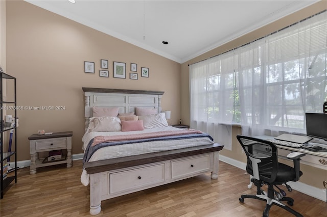 bedroom with light hardwood / wood-style flooring, ornamental molding, and vaulted ceiling