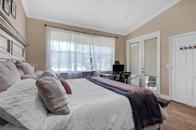 bedroom featuring lofted ceiling, crown molding, light hardwood / wood-style floors, and french doors