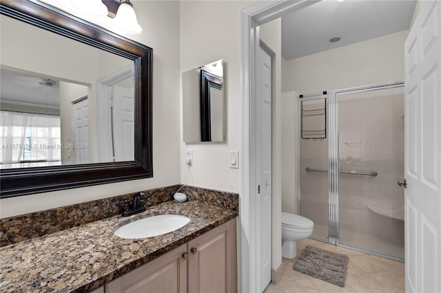 bathroom featuring vanity, toilet, tile patterned floors, and walk in shower