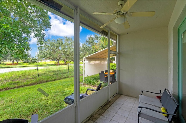 unfurnished sunroom with ceiling fan