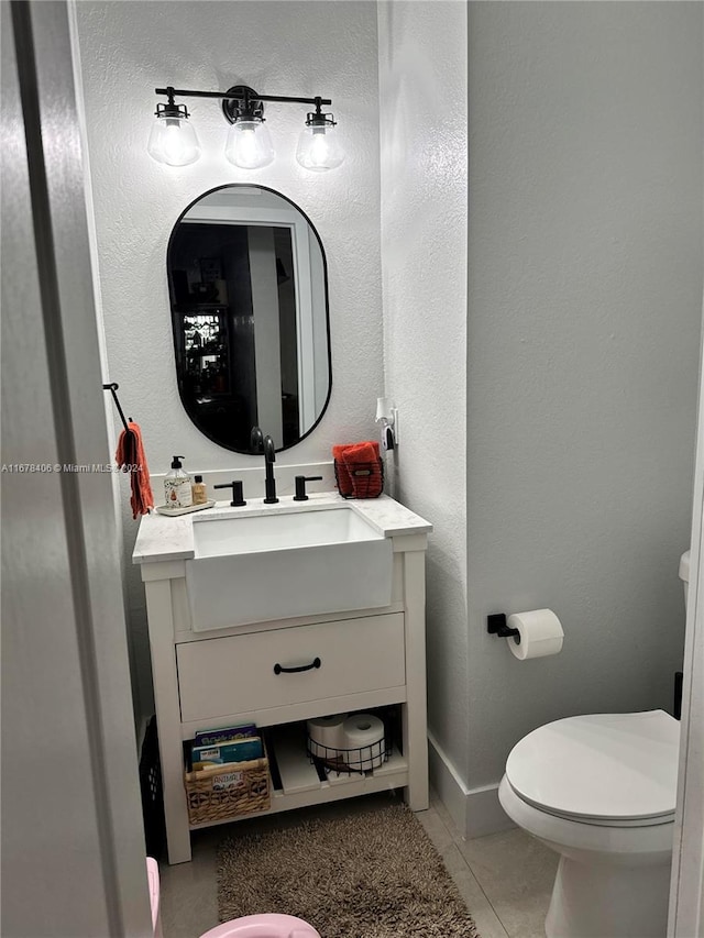 bathroom with vanity, toilet, and tile patterned floors