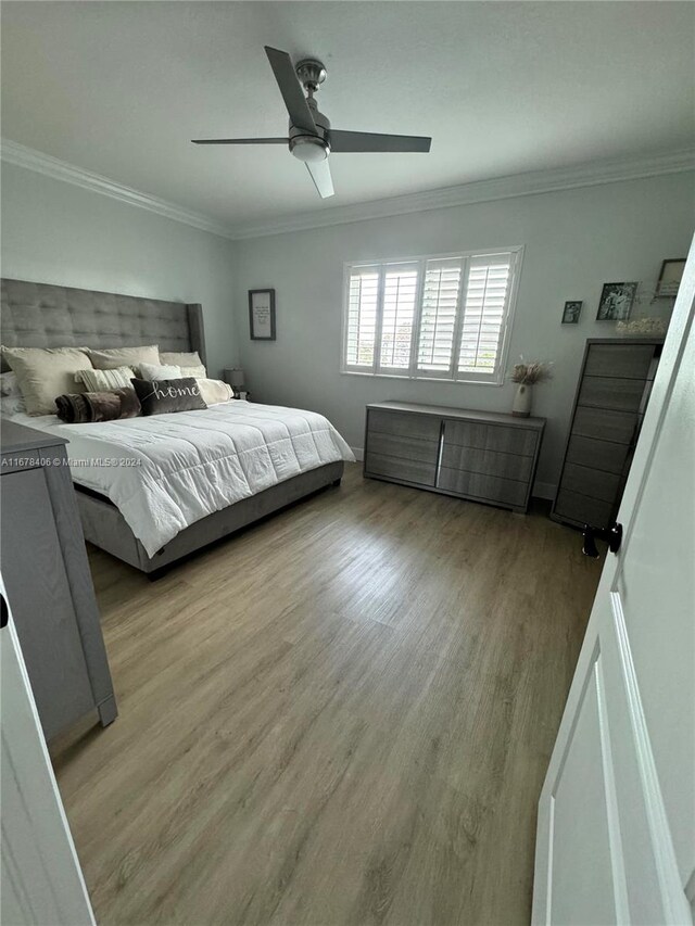 bedroom featuring crown molding, light hardwood / wood-style floors, and ceiling fan