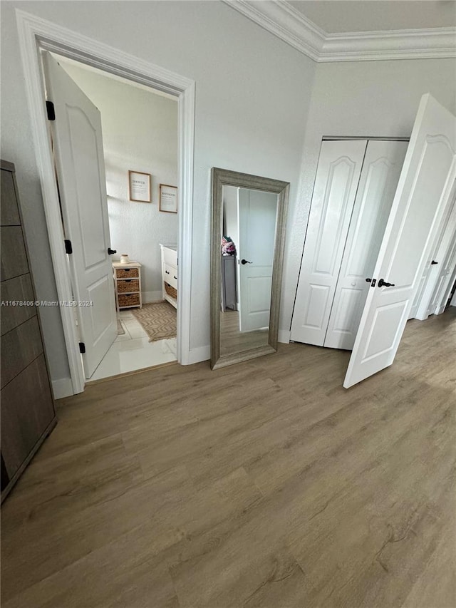 unfurnished bedroom with light hardwood / wood-style floors and crown molding