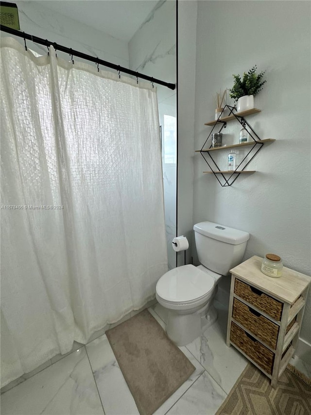 bathroom featuring toilet and curtained shower