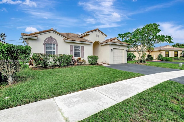 mediterranean / spanish house with a front yard and a garage