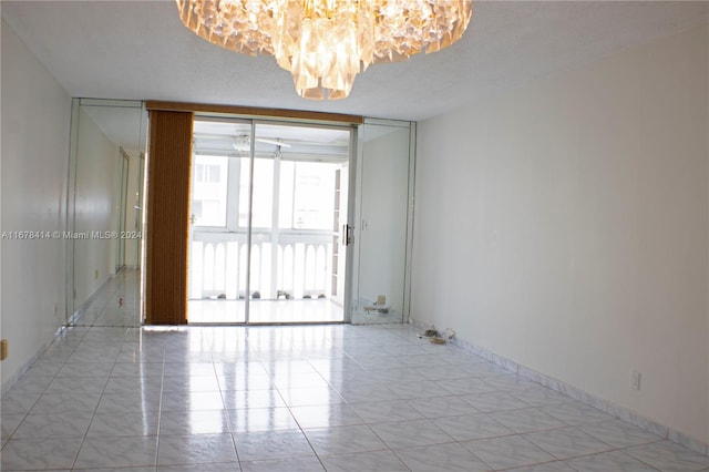 empty room featuring expansive windows, a textured ceiling, and light tile patterned floors