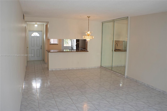 interior space with sink, a chandelier, and a textured ceiling