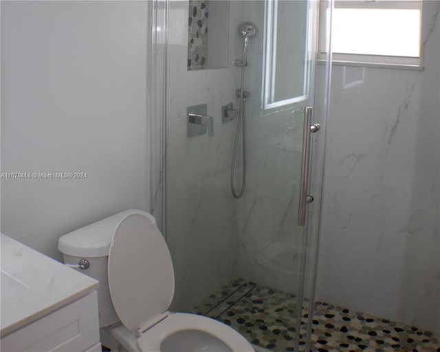 bathroom featuring vanity, toilet, and an enclosed shower