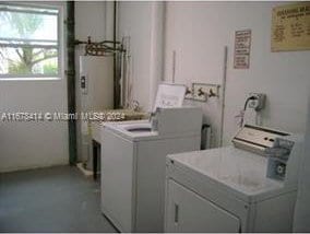 washroom featuring electric water heater and washing machine and dryer