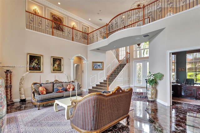 living room featuring ornate columns, french doors, and a towering ceiling