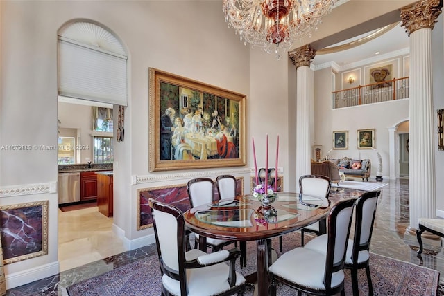 dining area with a high ceiling, ornate columns, and a notable chandelier